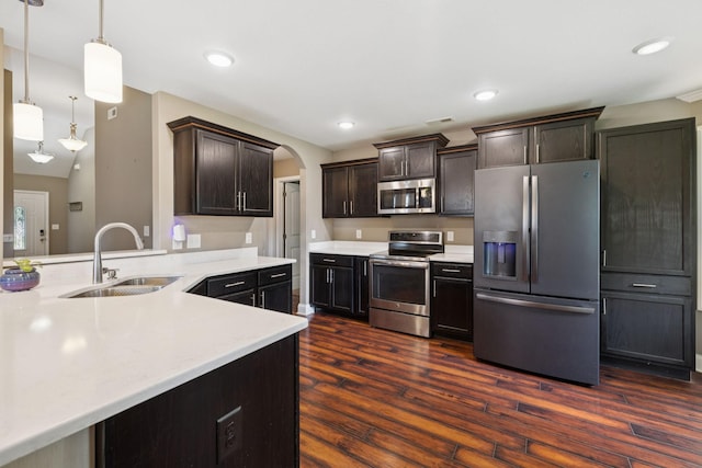 510 Sourwood Dr, Clarksville, TN 37042 - kitchen featuring stainless steel appliances, light countertops, arched walkways, dark brown cabinetry, and dark wood finished floors