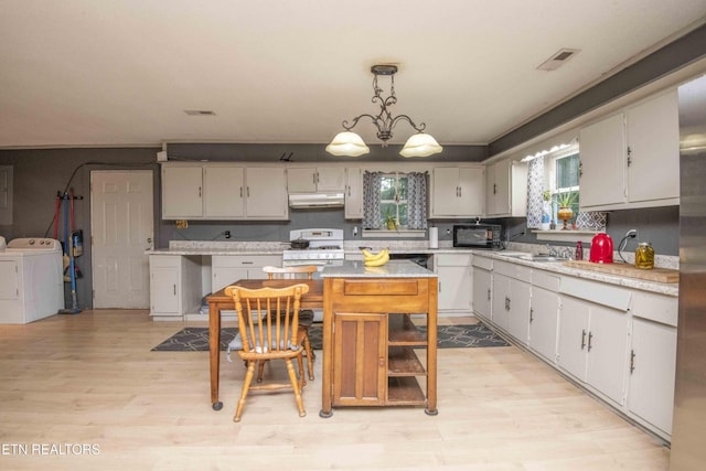 197 Wedgewood Ln, Spring City, TN 37381 - kitchen featuring independent washer and dryer, white gas stove, light countertops, light wood-style flooring, and pendant lighting