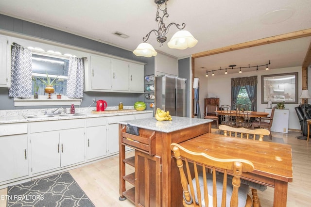 197 Wedgewood Ln, Spring City, TN 37381 - kitchen featuring freestanding refrigerator, light wood-style flooring, white cabinets, and hanging light fixtures