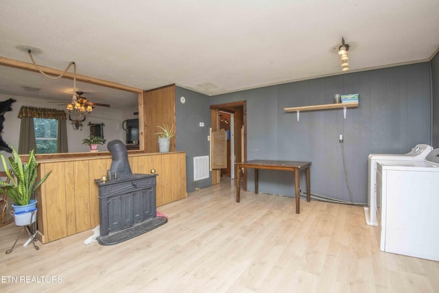 197 Wedgewood Ln, Spring City, TN 37381 - kitchen with a wood stove, light wood-style floors, washer and clothes dryer, and ceiling fan