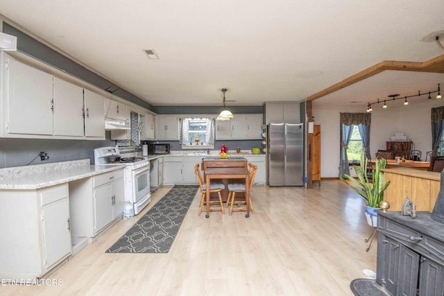 197 Wedgewood Ln, Spring City, TN 37381 - kitchen featuring white gas stove, freestanding refrigerator, light wood-style flooring, light countertops, and decorative light fixtures