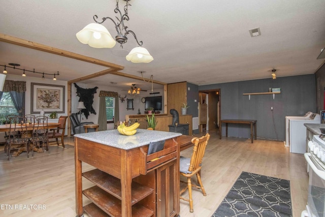 197 Wedgewood Ln, Spring City, TN 37381 - kitchen featuring washing machine and dryer, white gas range oven, light wood finished floors, and a center island
