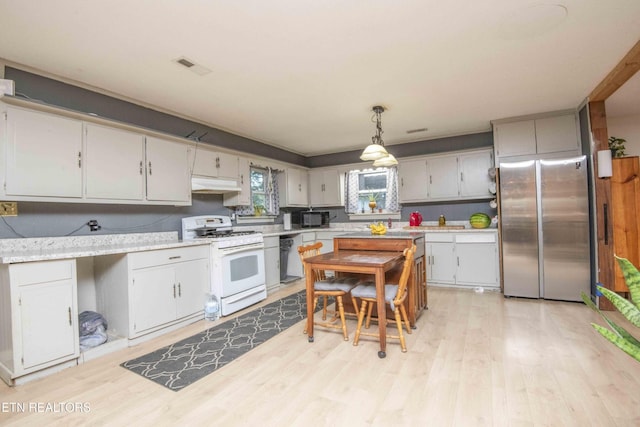 197 Wedgewood Ln, Spring City, TN 37381 - kitchen with freestanding refrigerator, gas range gas stove, under cabinet range hood, light countertops, and light wood-type flooring