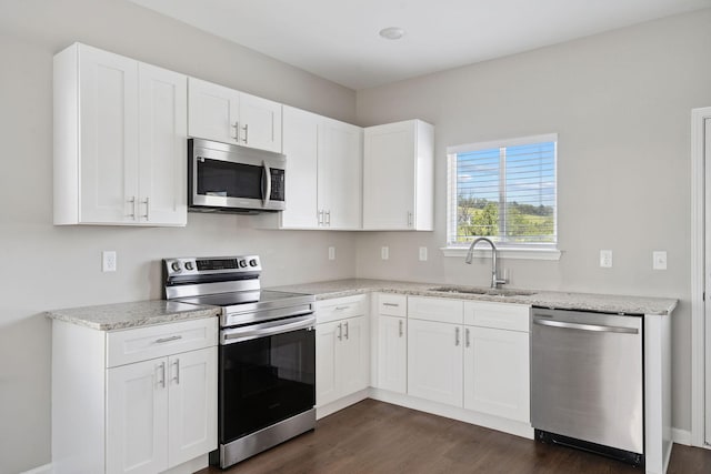 241 Tara Ct, Columbia, TN 38401 - kitchen featuring appliances with stainless steel finishes, dark wood finished floors, white cabinetry, and light stone countertops