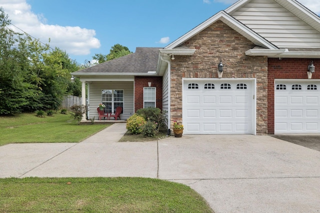 1609 Merritt St Unit A, Old Hickory, TN 37138 - view of front of property featuring concrete driveway, stone siding, a garage, a front lawn, and roof with shingles