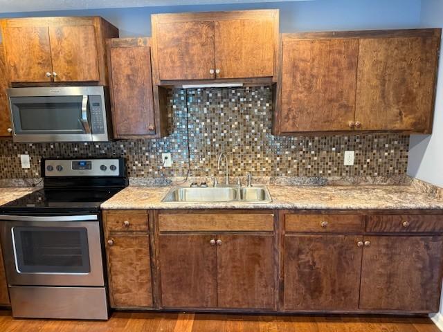 208 Broadrick St, Tullahoma, TN 37388 - kitchen with appliances with stainless steel finishes, wood finished floors, and decorative backsplash