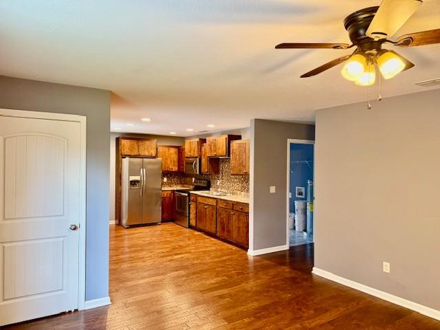 208 Broadrick St, Tullahoma, TN 37388 - kitchen with appliances with stainless steel finishes, brown cabinetry, light countertops, tasteful backsplash, and a ceiling fan