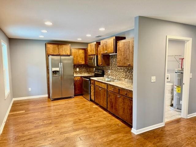 208 Broadrick St, Tullahoma, TN 37388 - kitchen with stainless steel appliances, water heater, backsplash, light wood-type flooring, and recessed lighting