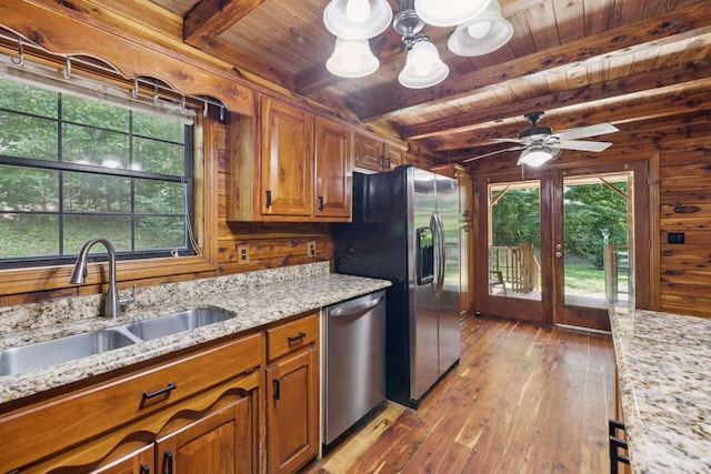 584 Mccord Hollow Rd, Hohenwald, TN 38462 - kitchen featuring stainless steel appliances, a wood ceiling with exposed beams, wood-type flooring, brown cabinets, and wood walls