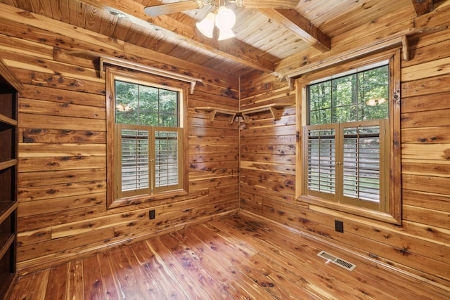 584 Mccord Hollow Rd, Hohenwald, TN 38462 - unfurnished room featuring a wood ceiling with exposed beams, plenty of natural light, wood walls, wood-type flooring, and a ceiling fan