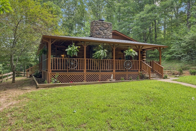 584 Mccord Hollow Rd, Hohenwald, TN 38462 - view of front of house with a chimney, covered porch, and log siding
