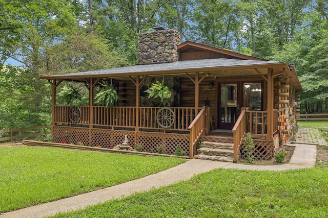 584 Mccord Hollow Rd, Hohenwald, TN 38462 - view of front of property featuring log siding, a chimney, and covered porch