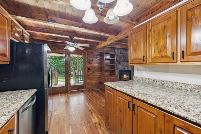584 Mccord Hollow Rd, Hohenwald, TN 38462 - kitchen featuring a wooden ceiling with exposed beams, dark wood-style floors, appliances with stainless steel finishes, wooden walls, and brown cabinetry