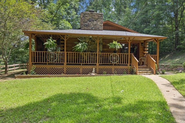 584 Mccord Hollow Rd, Hohenwald, TN 38462 - view of front of property featuring log siding, a chimney, and covered porch