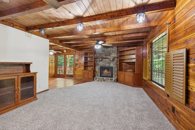 584 Mccord Hollow Rd, Hohenwald, TN 38462 - unfurnished living room featuring ceiling fan, a fireplace, carpet, plenty of natural light, and a wood ceiling with exposed beams