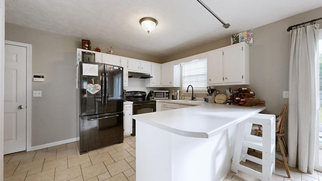 2806 Holsted Dr, Murfreesboro, TN 37128 - kitchen with black appliances, under cabinet range hood, a peninsula, white cabinetry, and light countertops