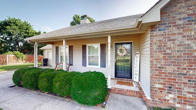 2806 Holsted Dr, Murfreesboro, TN 37128 - doorway to property featuring covered porch, a chimney, a shingled roof, and brick siding