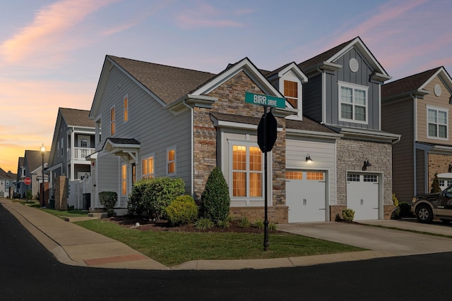 401 Birr Dr, Spring Hill, TN 37174 - view of front facade with stone siding, a garage, concrete driveway, and board and batten siding