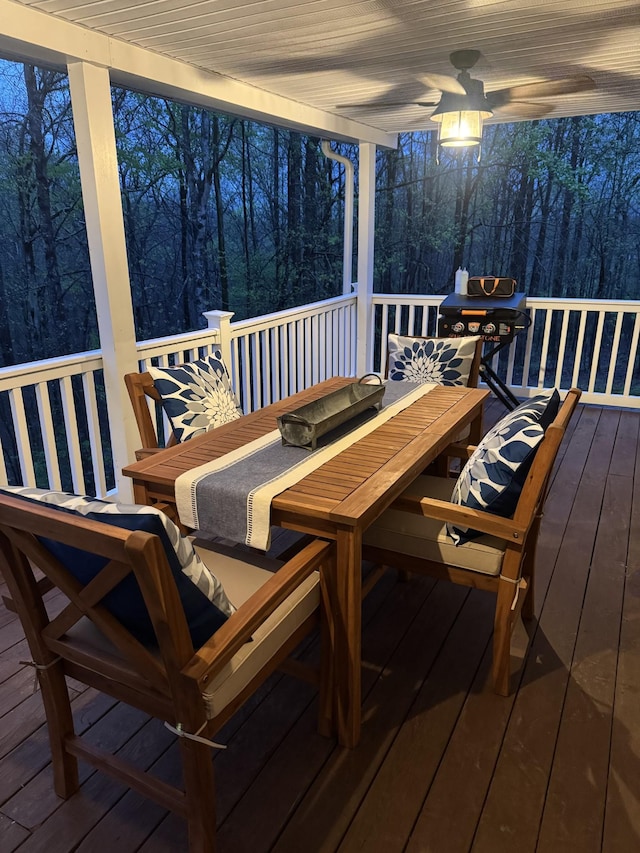 217 Red Oak Rd, Dover, TN 37058 - wooden terrace with outdoor dining area, a ceiling fan, and a wooded view