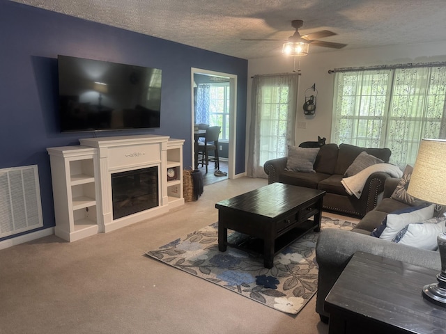 217 Red Oak Rd, Dover, TN 37058 - living room featuring a ceiling fan, carpet, a textured ceiling, and a glass covered fireplace