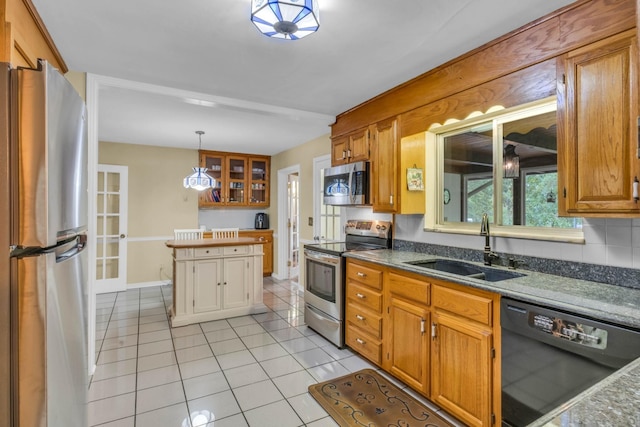 499 Pettus St, Lawrenceburg, TN 38464 - kitchen with appliances with stainless steel finishes, light tile patterned floors, glass insert cabinets, pendant lighting, and brown cabinets