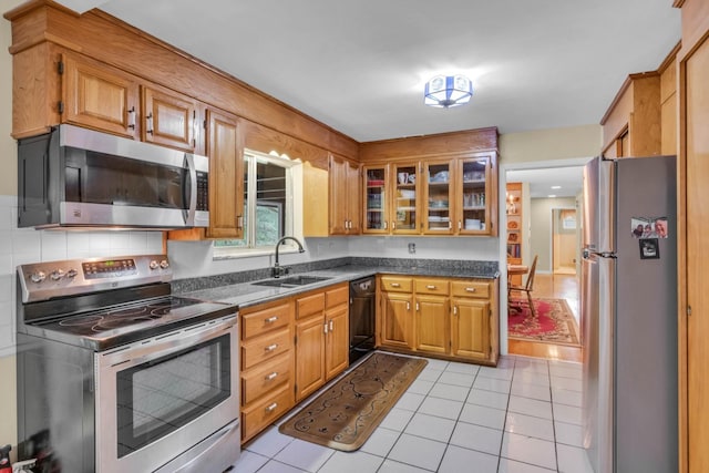 499 Pettus St, Lawrenceburg, TN 38464 - kitchen with appliances with stainless steel finishes, light tile patterned floors, brown cabinets, glass insert cabinets, and tasteful backsplash