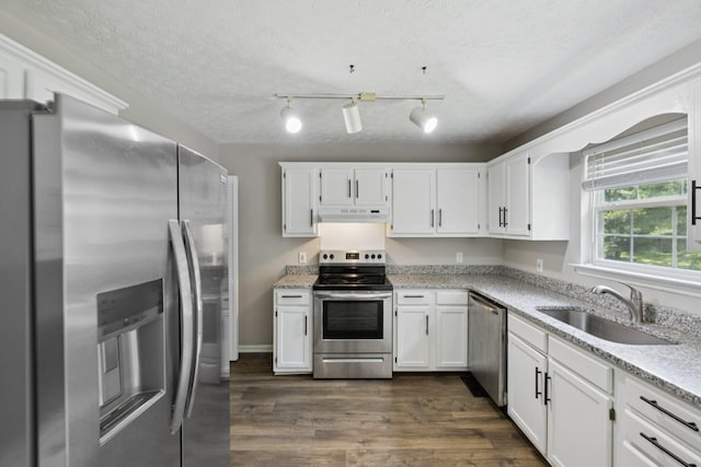 7616 Hudlow Ct, Fairview, TN 37062 - kitchen featuring appliances with stainless steel finishes, under cabinet range hood, white cabinets, dark wood finished floors, and a textured ceiling