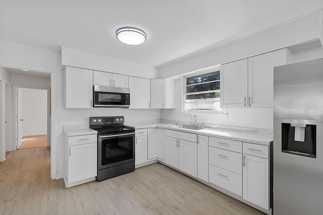 1401 Bearwallow Rd, Ashland City, TN 37015 - kitchen featuring appliances with stainless steel finishes, light wood-type flooring, white cabinetry, crown molding, and light stone countertops