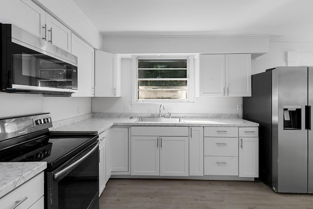 1401 Bearwallow Rd, Ashland City, TN 37015 - kitchen featuring appliances with stainless steel finishes, white cabinetry, and light wood-style flooring