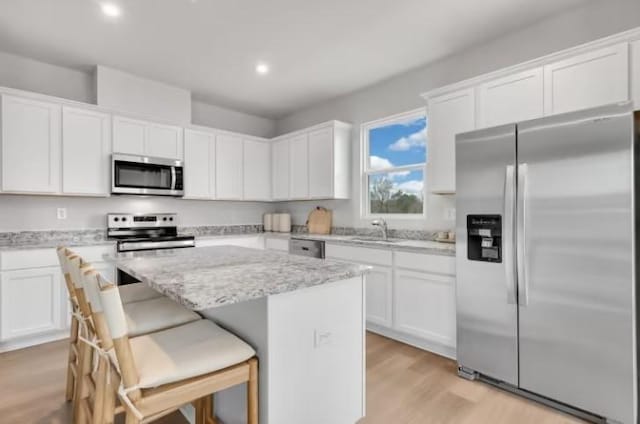 3294 Barrel Oak Pass, Columbia, TN 38401 - kitchen featuring stainless steel appliances, a center island, white cabinets, recessed lighting, and light wood-type flooring
