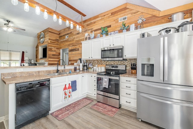 8100 Cedar Forrest Rd, Lascassas, TN 37085 - kitchen featuring stainless steel appliances, wooden walls, light wood finished floors, ceiling fan, and a peninsula