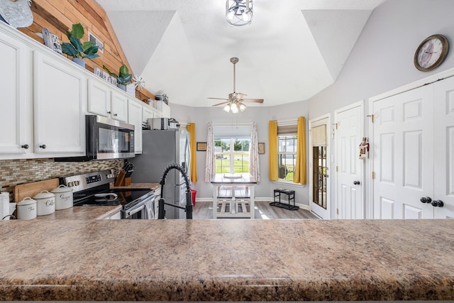 8100 Cedar Forrest Rd, Lascassas, TN 37085 - kitchen featuring appliances with stainless steel finishes, tasteful backsplash, lofted ceiling, white cabinetry, and wood finished floors