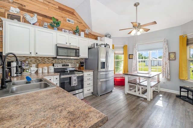 8100 Cedar Forrest Rd, Lascassas, TN 37085 - kitchen featuring stainless steel appliances, decorative backsplash, ceiling fan, dark wood-type flooring, and wooden walls