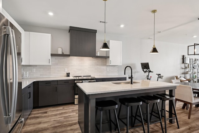 2006 Edison Park Ln, Nashville, TN 37209 - kitchen featuring appliances with stainless steel finishes, decorative backsplash, wood finished floors, a kitchen breakfast bar, and white cabinets