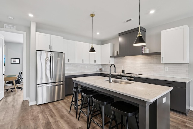 2006 Edison Park Ln, Nashville, TN 37209 - kitchen with appliances with stainless steel finishes, tasteful backsplash, an island with sink, light stone counters, and recessed lighting