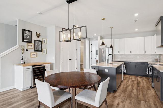 2006 Edison Park Ln, Nashville, TN 37209 - dining area with wine cooler, light wood-type flooring, a dry bar, a chandelier, and recessed lighting