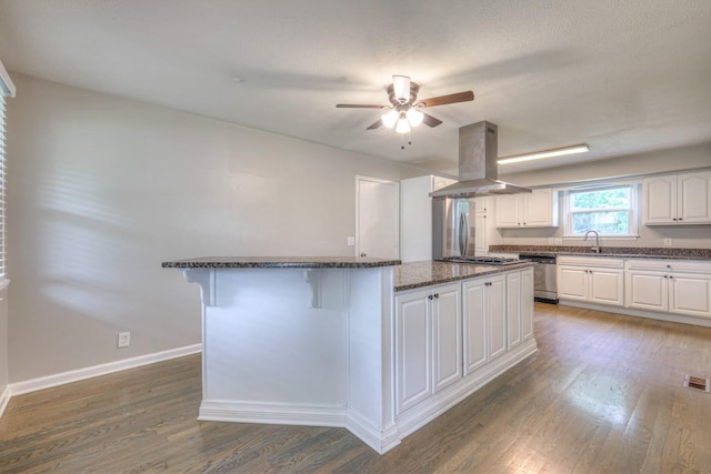 1213 N Graycroft Ave, Madison, TN 37115 - kitchen with island exhaust hood, a center island, wood finished floors, a breakfast bar, and appliances with stainless steel finishes
