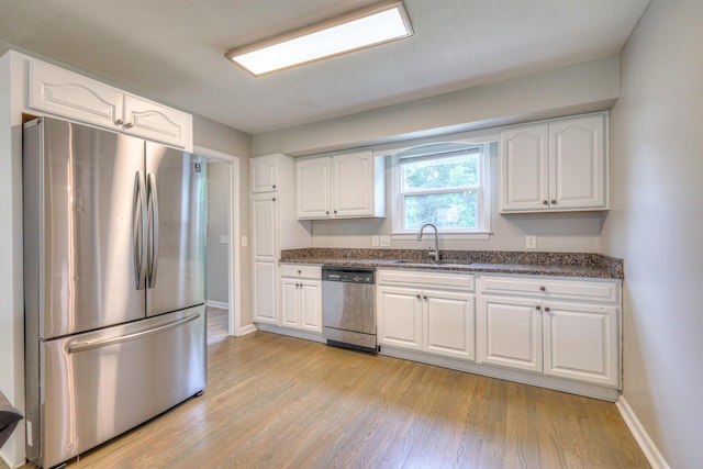 1213 N Graycroft Ave, Madison, TN 37115 - kitchen with appliances with stainless steel finishes, light wood-type flooring, white cabinets, and dark stone counters