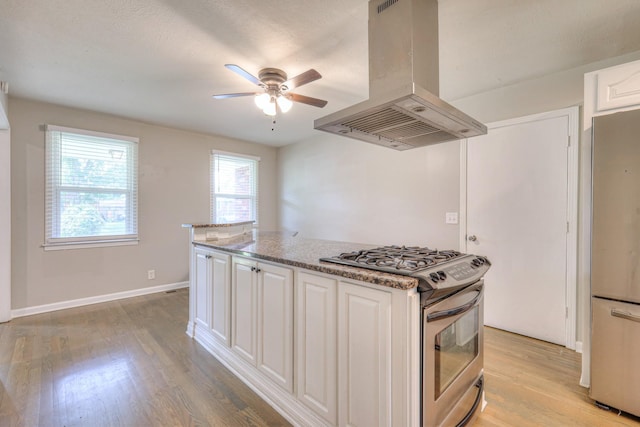 1213 N Graycroft Ave, Madison, TN 37115 - kitchen with island range hood, stainless steel appliances, white cabinets, light wood-style flooring, and ceiling fan