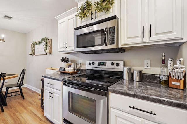 1319 Knoll Ln, Lebanon, TN 37087 - kitchen with stainless steel appliances, dark countertops, white cabinetry, and light wood-style flooring