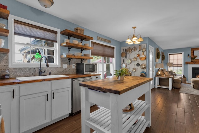 2105 Burgess Ln, Spring Hill, TN 37174 - kitchen with butcher block countertops, open shelves, stainless steel dishwasher, a chandelier, and backsplash
