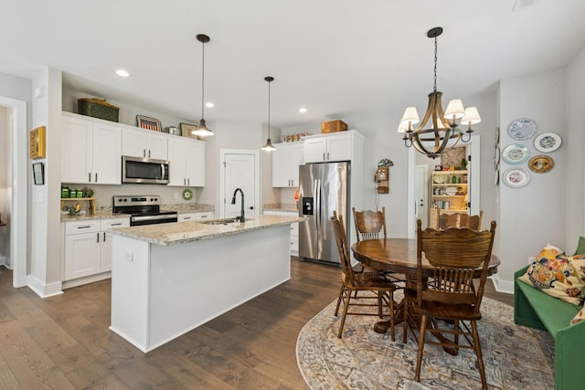 26 Sycamore Rdg W, Burns, TN 37029 - kitchen featuring appliances with stainless steel finishes, dark wood finished floors, a center island with sink, white cabinetry, and recessed lighting