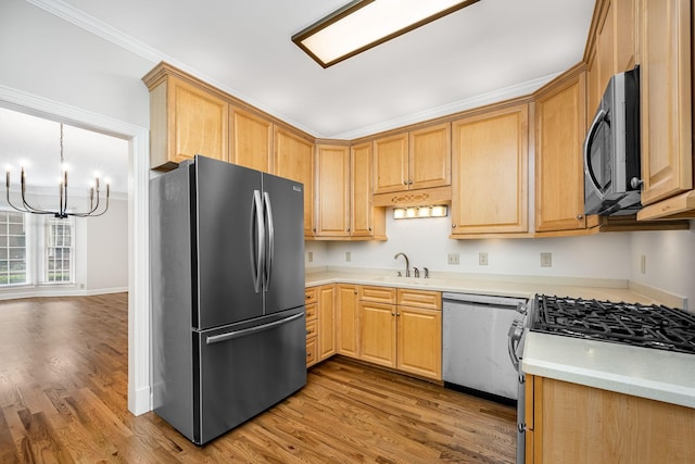 1436 Cheshire Pl, Murfreesboro, TN 37129 - kitchen with appliances with stainless steel finishes, a chandelier, wood finished floors, light countertops, and ornamental molding