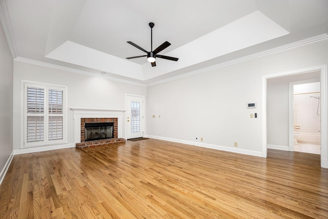 1436 Cheshire Pl, Murfreesboro, TN 37129 - unfurnished living room featuring a raised ceiling, a ceiling fan, a fireplace, light wood finished floors, and crown molding