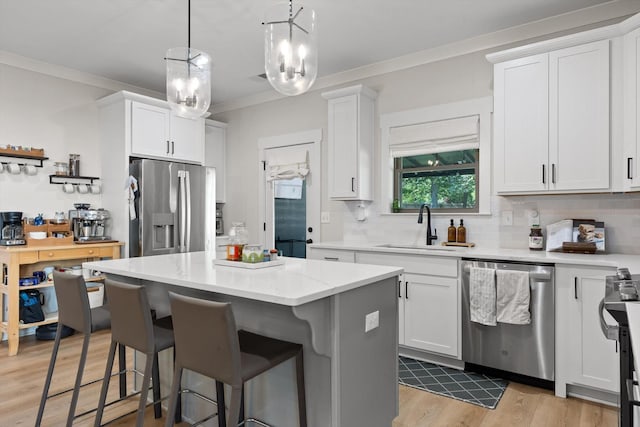 8408 Morin Rd, Chattanooga, TN 37421 - kitchen featuring stainless steel appliances, a kitchen breakfast bar, crown molding, white cabinetry, and decorative backsplash