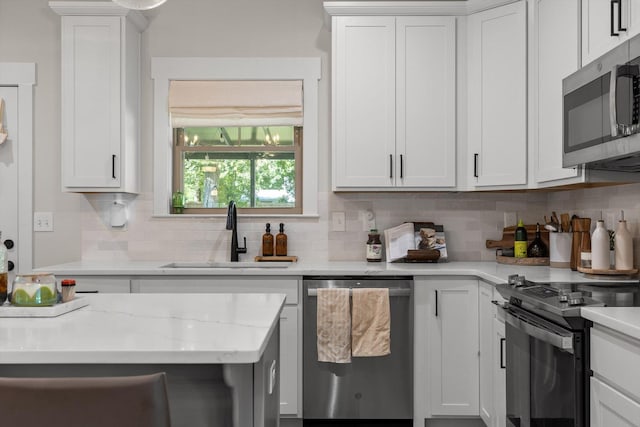 8408 Morin Rd, Chattanooga, TN 37421 - kitchen with appliances with stainless steel finishes, tasteful backsplash, white cabinets, and light stone counters