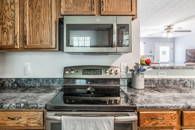 112 Ray Ave, Old Hickory, TN 37138 - kitchen featuring stainless steel appliances, a ceiling fan, brown cabinetry, and dark countertops