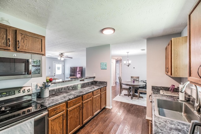 112 Ray Ave, Old Hickory, TN 37138 - kitchen with stainless steel appliances, brown cabinetry, dark wood finished floors, a ceiling fan, and dark countertops