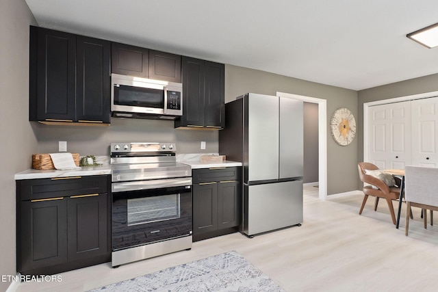 588 Meadowbrook Dr, Mcminnville, TN 37110 - kitchen with appliances with stainless steel finishes, light countertops, light wood finished floors, and dark cabinets
