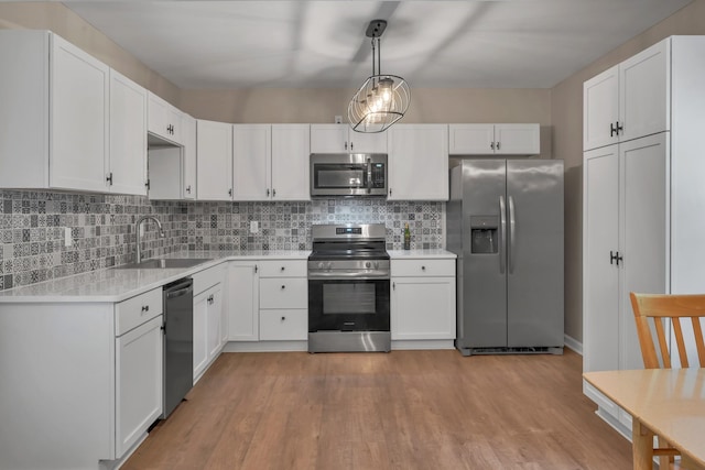 909 Woods Lake Dr, Madison, TN 37115 - kitchen featuring stainless steel appliances, light countertops, decorative backsplash, and light wood-type flooring